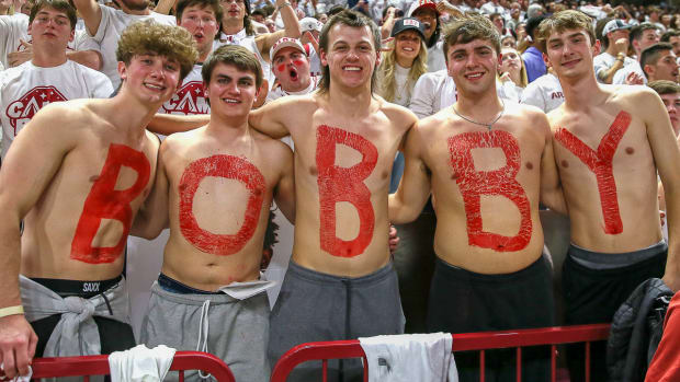 Fans at basketball game celebrating Bobby Petrino's return